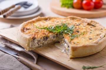 Traditional French Quiche with cheese, spinach and chicken. Quiche lorraine. French cuisine. Top view. Light wooden background