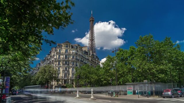 Eiffel Tower behind historic buildings in Paris timelapse hyperlapse, France. Blue cloudy sky at summer day with green trees and traffic on the street