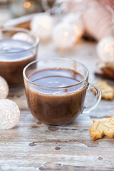 A cup of hot chocolate with cookies on the wooden table