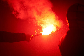 flaming red flare during a street protest in the city