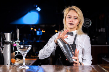 Girl barman makes a cocktail in the beerhouse