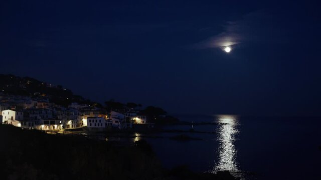 Beautiful Mediterranean village at evening. Night views on a small town on a sea coast. Water and lights of Calella de Palafrugell in Spain. Costa Brava vacation an chill. White houses on the beach..