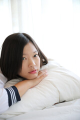  school girl sleeping on bed in white tone bedroom