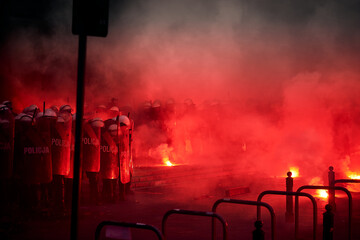 Police cordon and red flares during street protest - obrazy, fototapety, plakaty