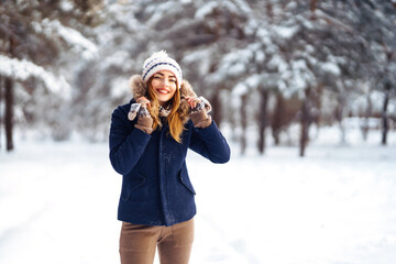 Portrait of Beautiful woman enjoys winter, frosty day. Fashion young woman in the snow forest....