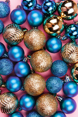 Christmas composition. Gold blue decorations on pastel pink background. Christmas, winter, new year concept. Flat lay, top view, copy space.