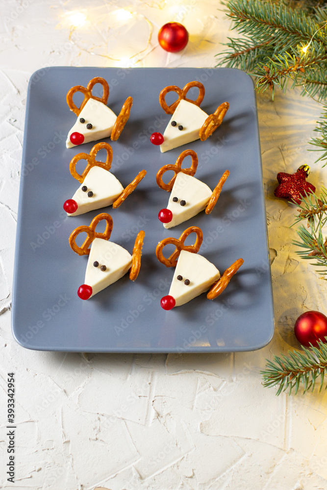 Sticker Funny christmas snack in a shapes of deer for kids party. Concept New year food from cheese and pretzels