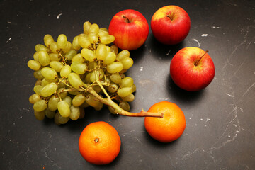 Fresh fruits on the kitchen black table. Healthy food from fresh fruits.