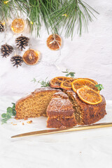Christmas orange and spice cake. Decorated with dried oranges on kitchen countertop