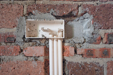 A room in a rough house under construction, with a red brick concrete structure