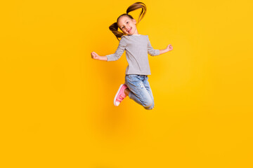 Full size photo of happy positive little girl child kid jump isolated on yellow color background