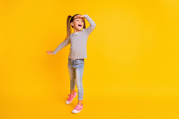 Full size photo of young smiling excited girl child kid hold hand on head look in distance...