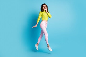 Fototapeta na wymiar Photo portrait full body view of cute woman jumping up walking touching face cheek with hand isolated on pastel blue colored background