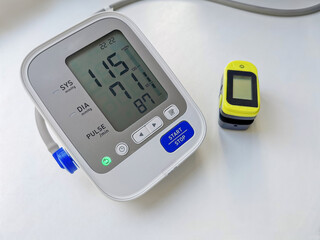 Included tonometer monitor with normal blood pressure readings and pulse oximeter on white background