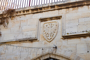 The hospitaller  coat of arms carved from stone on the wall in the Muristan Street in the Christian part of the old city of Jerusalem in Israel