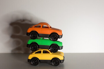 Three colorful toy cars made from recyclable non toxic plastic at white background with shadows, zero waste, saving energy concept 
