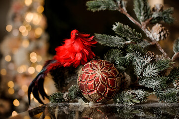 Obraz na płótnie Canvas beautiful Christmas toys shiny red ball and bright bird near fir branches