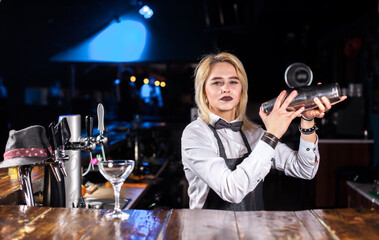 Girl bartender makes a cocktail at the pothouse