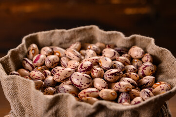 Colored beans on wooden background.