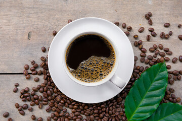 cup of coffee and bean on black wooden table background. top view