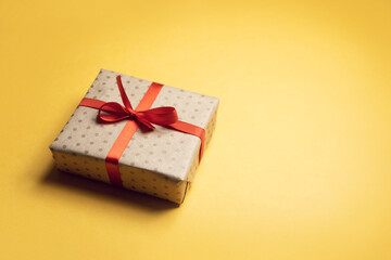 Gift box craft rope ribbon on yellow background. Gift on an isolated background, top view.