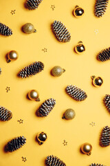 Christmas background with toys. Christmas gold ornaments on a yellow background. Flat layout, top view, copy space.
