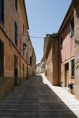 view of ground narrow street lane alley between houses with beautiful colours during summer in mallorca majorca