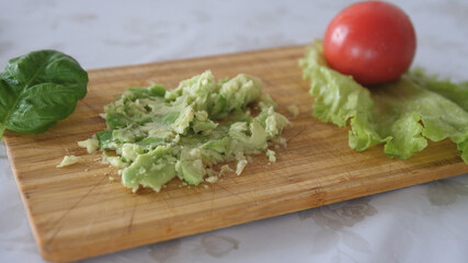 mashing avocado on a board. Cooking healthy food