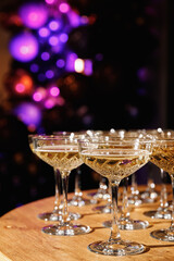Glasses with Sparkling Wine. champagne glasses over Holiday Bokeh Blinking background. Celebration, party concept.