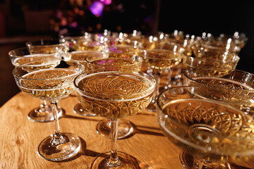 Glasses with Sparkling Wine. champagne glasses over Holiday Bokeh Blinking background. Celebration, party concept.