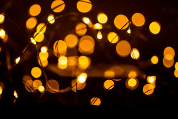 Yellow Christmas lights on black background. New Year celebration concept.