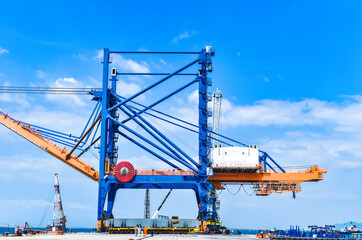 Fototapeta na wymiar Transporting huge quay crane using self-propelled modular transporter. Moving huge quay crane from ship to harbor. Transporting heavy machinery. 