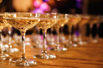 Glasses with Sparkling Wine. champagne glasses over Holiday Bokeh Blinking background. Celebration, party concept.