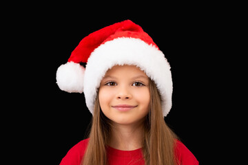Little girl in a Christmas hat posing.