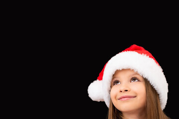 Little girl in a Christmas hat posing.