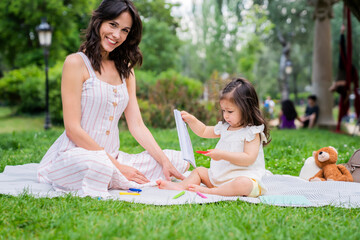 Happy young woman spending time with daughter in park