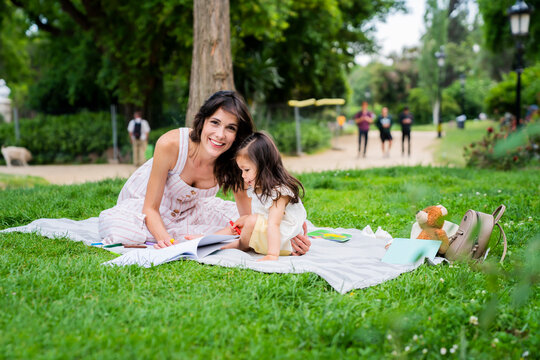 Mother and daughter drawing in park