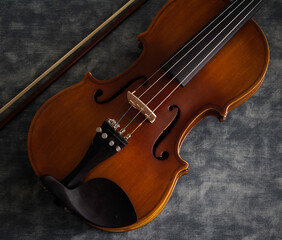 Fototapeta na wymiar Violin front side put beside bow on background,