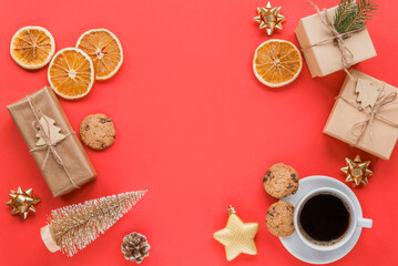 Christmas flat lay with gifts, a cup of coffee, cookies, oranges and decorations on red background. New Year concept
