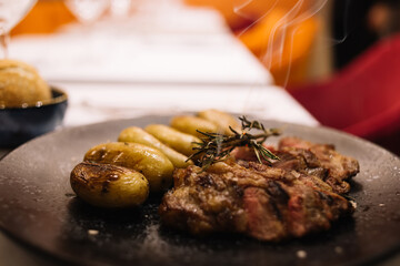 Grilled steak with potatoes on plate in cafe