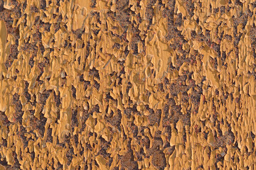 Surface is old paint for the backdrop. Yellow. Flaking, cracking.