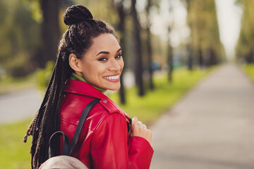 Photo of young cheerful attractive afro woman happy positive smile enjoy autumn walk park weekend look back