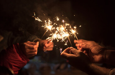 Group of happy people holding sparklers at parties celebrate.Young men and women enjoying with fireworks.