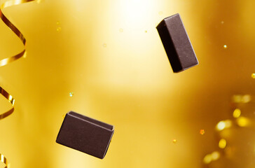 Creative photo of levitating gift box on golden background. Copy space. Celebration atmosphere. Christmas present promo