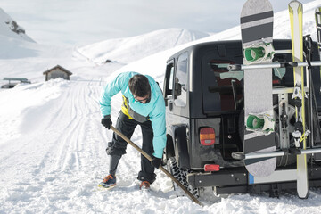Man clearing ice from under the car