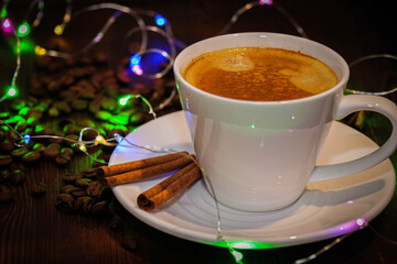 Delicious hot coffee. Hot drink.  A cup of coffee with froth. Coffee beans, cinnamon and anise