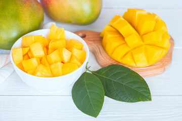 mango slices in a bowl and on a cutting Board close-up. white background with mango.