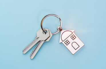 key chain with house symbol and keys on blue background,Real estate concept