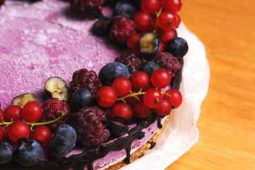Naklejka na ściany i meble Festive cake, blueberry and blackberry sponge cake with cream cheese inside on a plate on a wooden table, horizontal view from above.Macro photo.
