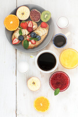 A plate with sweet sandwiches (peanut butter), fruits and aromatic coffee for an invigorating morning.